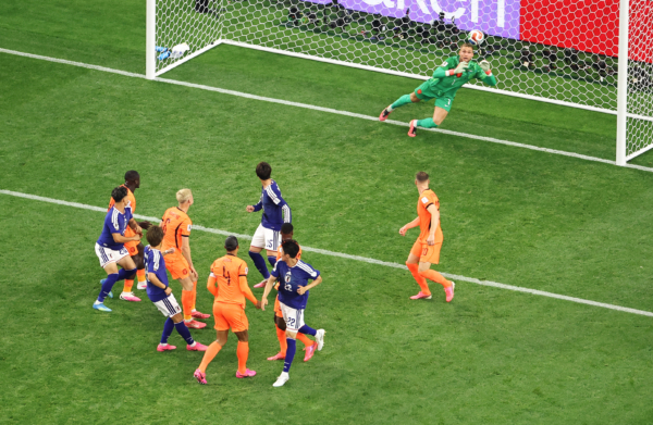 ARLINGTON, TEXAS - JUNE 14: Koki Ogawa #19 of Japan heads the ball, which is deflected off the head of Daichi Kamada #15 for the team's second goal during the FIFA World Cup 2026 Group F match between Netherlands and Japan at Dallas Stadium on June 14, 2026 in Arlington, Texas.