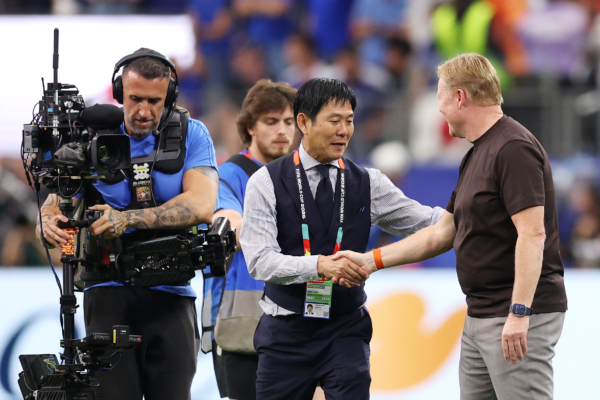 ARLINGTON, TEXAS - JUNE 14: Hajime Moriyasu, Head Coach of Japan, and Ronald Koeman, Head Coach of Netherlands, shake hands after the 2-2 draw during the FIFA World Cup 2026 Group F match between Netherlands and Japan at Dallas Stadium on June 14, 2026 in Arlington, Texas.